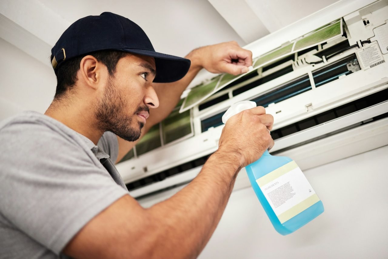 air-conditioner-cleaning-and-man-with-electrical-machine-check-in-a-home-with-ac-repair-maintenan.jpg