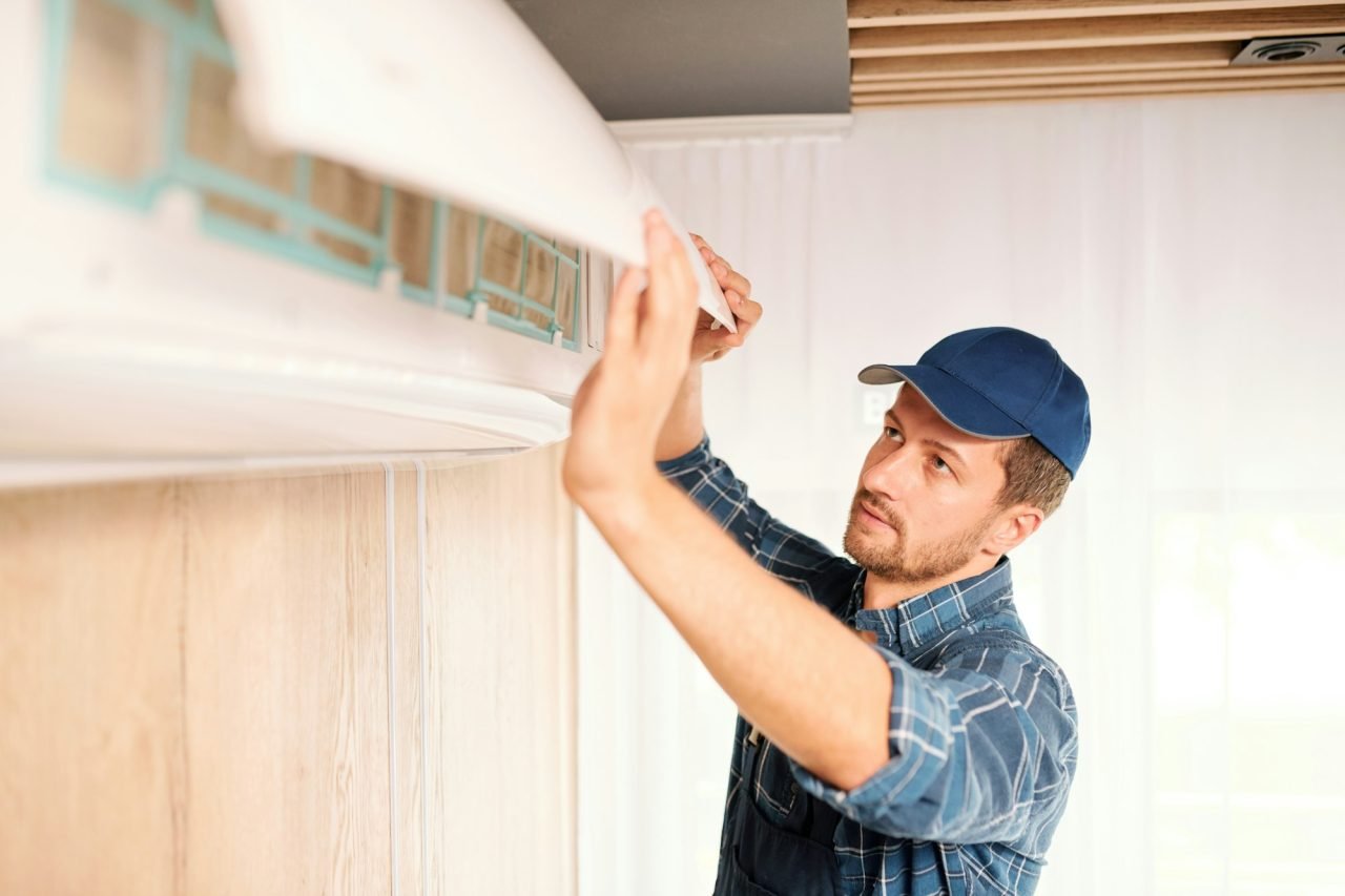 young-electrician-or-repiar-service-technician-opening-lid-of-air-conditioner.jpg