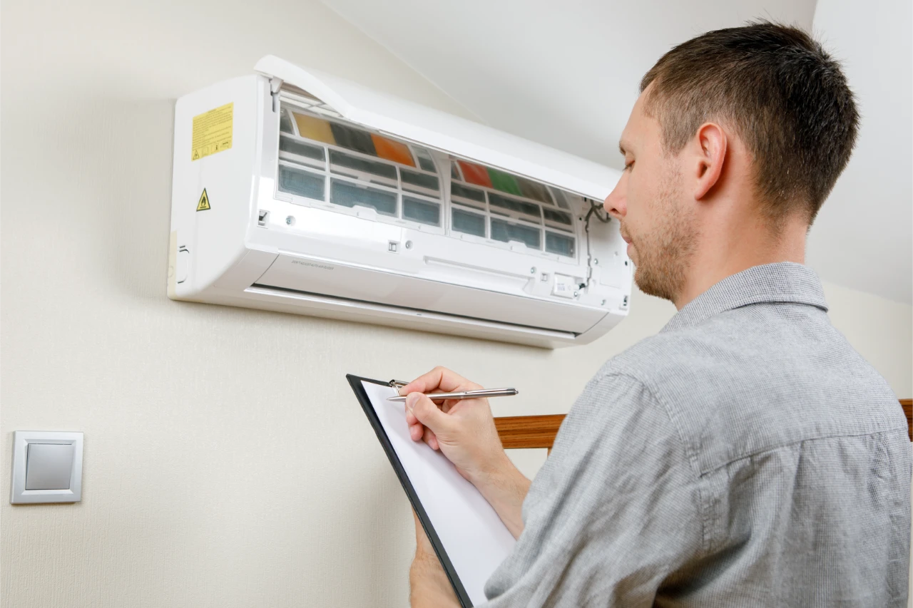 male-technician-cleaning-air-conditioner-indoors