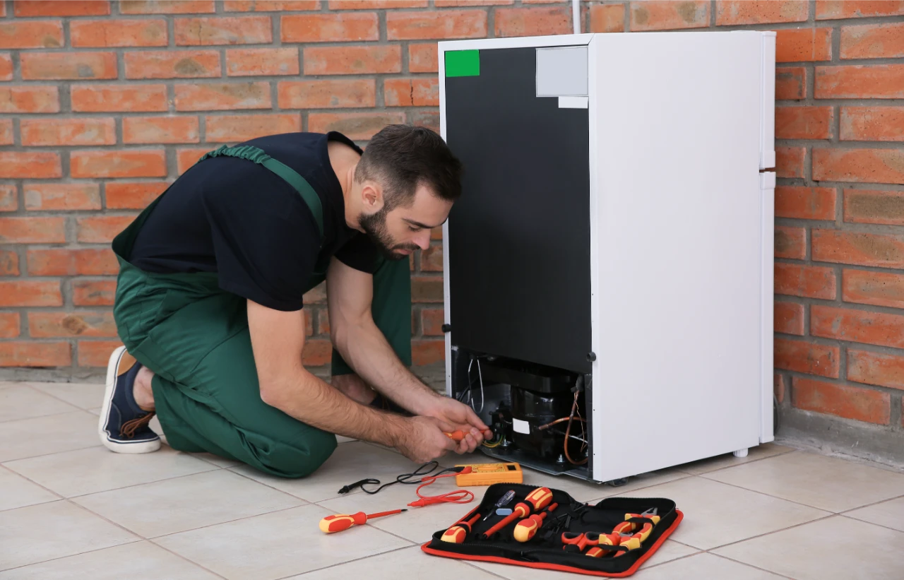 male-technician-uniform-repairing-refrigerator-indoors