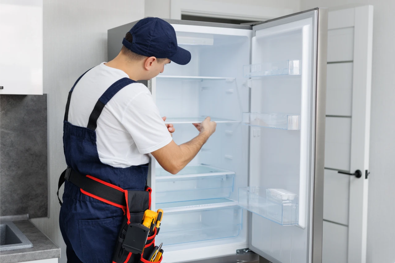 man-uniform-with-tools-is-repairing-refrigerator-kitchen